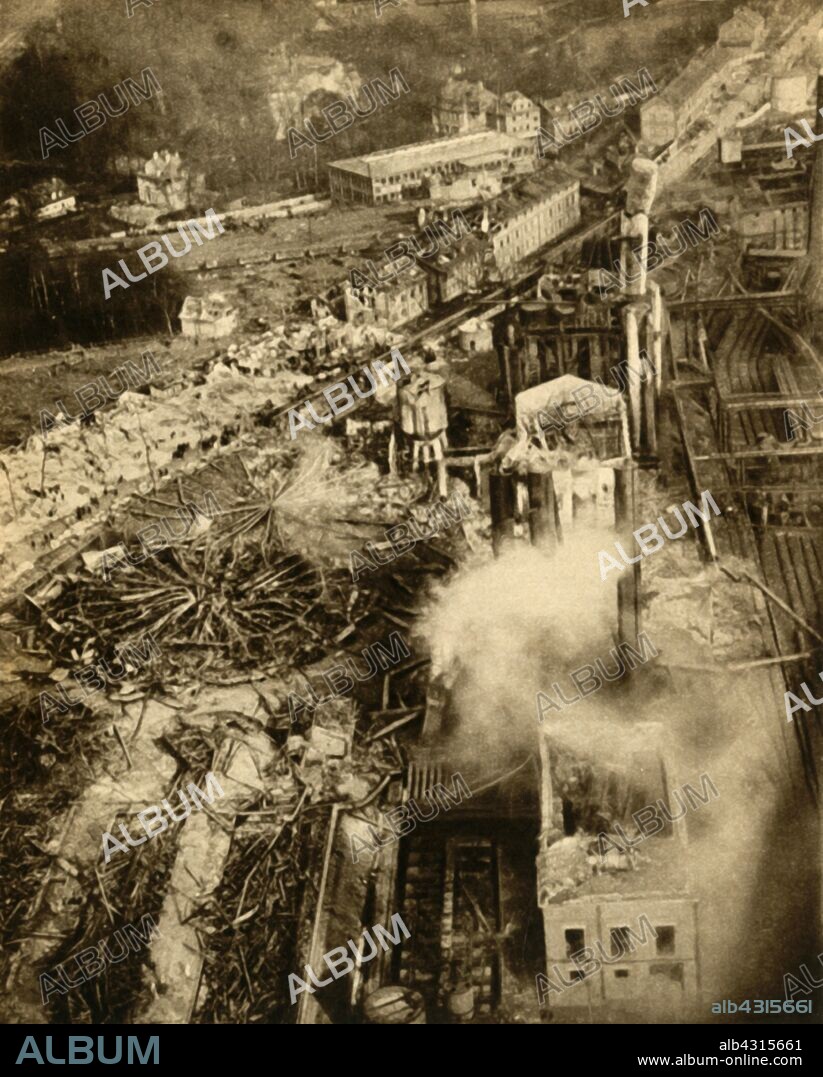 Gas explosion at Neunkirchen, Saarland, Germany, February 1933. 'Sixty-odd people were killed and over 1,000 injured when a gas-holder exploded at Neunkirchen in the Saar. The report was heard well over 100 miles away and fragments of the gas-holder flung half a mile through the air.'  From "The Pageant of the Century". [Odhams Press Ltd, 1933].