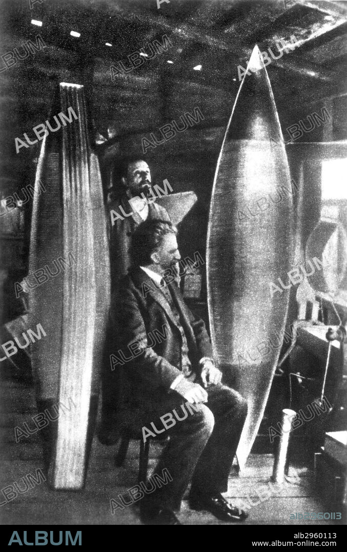KONSTANTIN TSIOLKOVSKY(1857-1935). Russian aeronautical engineer. Tsiolkovsky, seated, and his assistant V. Assonov, with models of his aerostat, or dirigible.