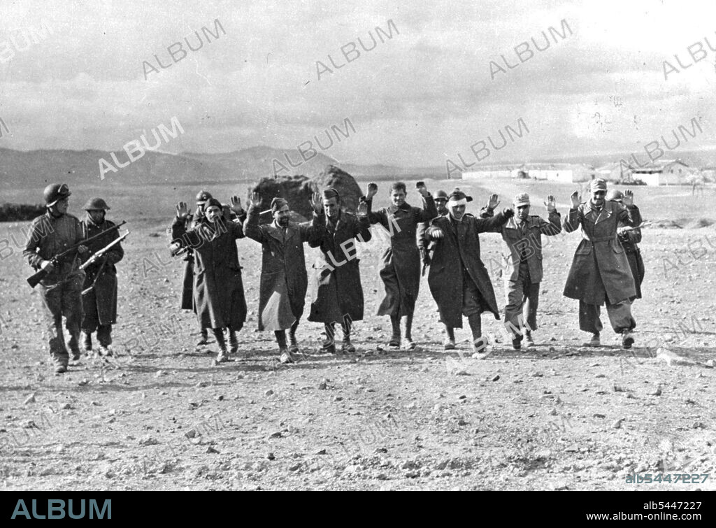 Axis Prisoners Captured in Tunisia These German and Italian prisoners were captured during the successful American counter-attack at Kasserine Pass, Tunisia. They are being marched to the rear by Allied soldiers. January 1, 1943. (Photo by U.S. Office of War Information Picture).
