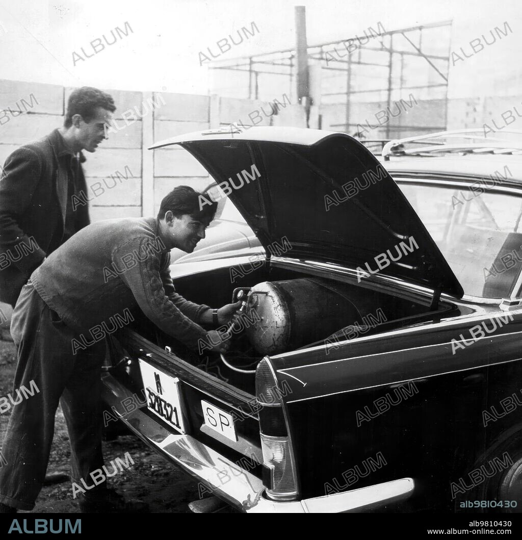19 diciembre 1962. Taxista Colocando las Bombonas de butano en el taxi.