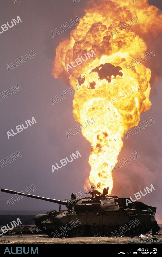 Kuwait City, Kuwait; March 1991. An abandoned Iraqi T-55 tank sits in the middle of a lake of spilling crude oil and surrounded by burning oil fields on the outskirts of Kuwait City during the Gulf War. The oil fields were set on fire by retreating Iraqi troops hoping to create some cover from American airplanes strafing their positions. The fires and smoke caused one of the greatest environmental disasters of modern times. Nearly 800 oil wells were set ablaze by the retreating Iraqi army and the fires were not fully extinguished until November 6, 1991, eight months after the end of the war. The fires consumed an estimated six million barrels of oil daily. Their immediate consequence was a dramatic decrease in air quality, causing respiratory problems for many Kuwaitis. The sabotage of the oil wells also impacted the desert environment, which has a limited natural cleansing ability. Un-ignited oil from the wells formed about 300 oil lakes that contaminated around 40 million tons of sand and earth.