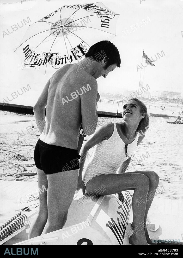 CANNES 1967. Filmfestivalen i Cannes. Thommy Berggren och Pia Degermark kopplar av under en "Elvira Madigan"-parasoll på plagen i Cannes.. Foto: Lars Åström / Skånereportage/ Bonnierarkivet . Kod: 36100 COPYRIGHT SCANPIX.