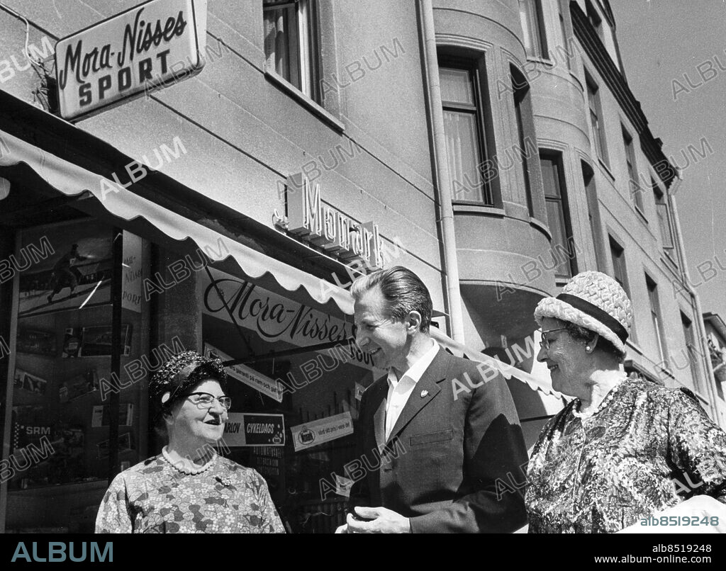 Mora 1967-06-14. Skidåkaren Nils "Mora-Nisse" Karlsson med Elna Johansson, 74, och Siri Johansson, 73, framför sin affär i Mora. Foto: Leif Engberg / DN / TT / Kod: 15. ** SvD OUT **.