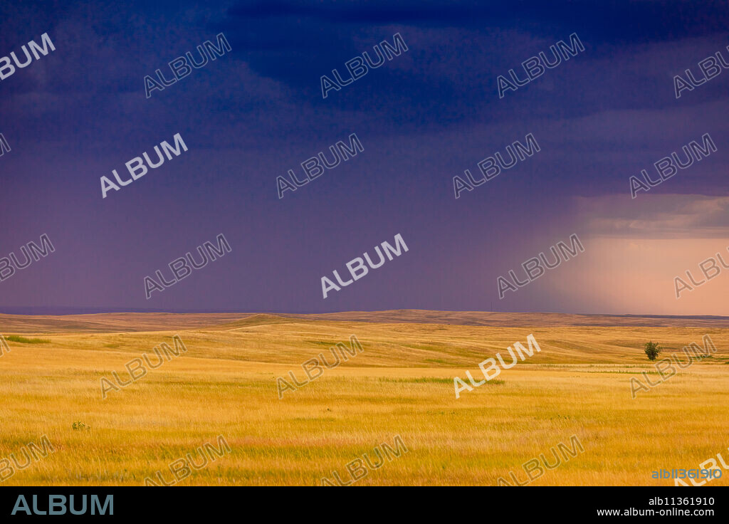 Rolling plains against a dark stormy sky in the Badlands, South Dakota, United States of America, North America.