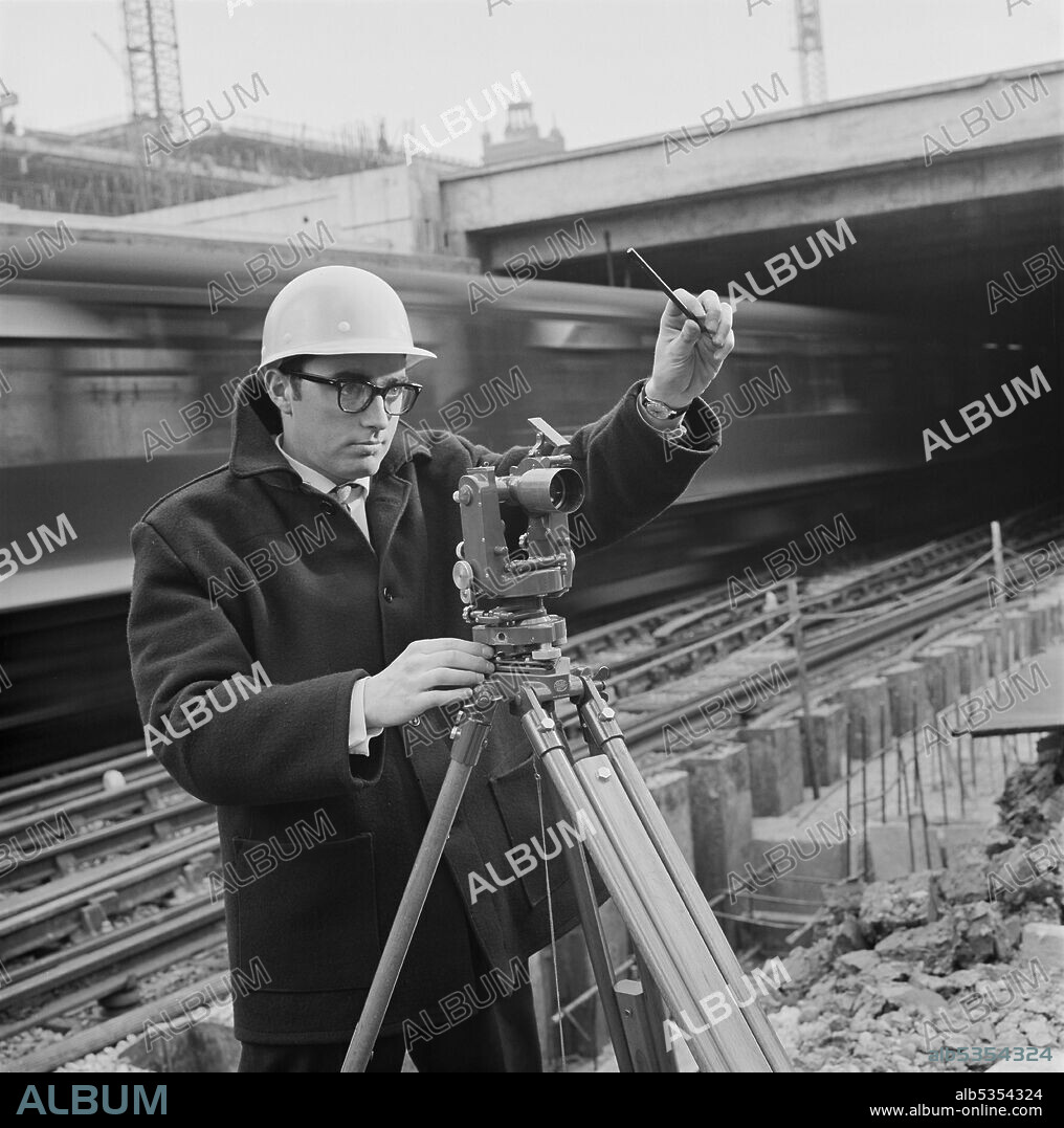 JOHN LAING PLC. A Laing surveyor using a theodolite instrument, stood in front of a railway line on the construction site of the Barbican development. Work began on building London’s Barbican development in 1962. The construction of this complex megastructure was designed to be carried out in six phases, with different contractors working on the site. In 1964 John Laing and Son Ltd won the tender for Phase III, and they finished Speed House in 1968. The Company were also responsible for the construction of the Barbican Arts Centre (Phase V), which began in the early 1970s and was completed in 1981.
