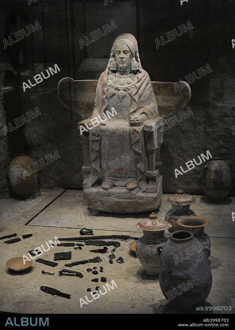 Lady of Baza. Sculpture and goods from the Grave 155 of Baza. Iberian female sculpture sitting on a winged chair and holding a pigeon in her hand. 4th century BC. Polychrome sandstone. Found in the Cerro del Santuario (Basti, Baza, province of Granada, Andalusia, Spain). National Archaeological Museum. Madrid. Spain.