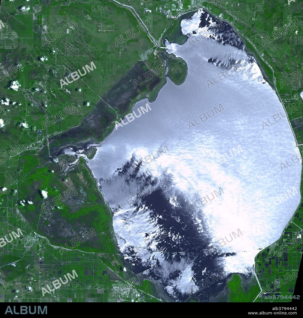 Due to months of intense drought, water levels in Florida's Lake Okeechobee hit record low levels in May and June of 2007, and swampy vegetation around the retreating shoreline began to dry out. At the end of May, more than 10,000 acres of desiccated vegetation burned in a fast-moving, wind-driven wildfire. This image shows the burn scar left on the landscape by the fire, captured on June 23, 2007, by the Advanced Spaceborne Thermal Emission and Reflection Radiometer (ASTER) on NASA's Terra satellite. The image shows a huge scorched swath (long bluish patch between lake and green area at top left) of the marsh between the lake and the surrounding Herbert Hoover Dyke (extreme left of burn scar). The burned area appears charcoal, while vegetation appears green. Lake Okeechobee reflects bright sunlight off of its surface. Lake Okeechobee water levels were nearly 4.5 feet below their long-term average (1965-2006) for this time of year. Much of the area between the burn scar and the lake itself was previously underwater; it was exposed as the water level fell.