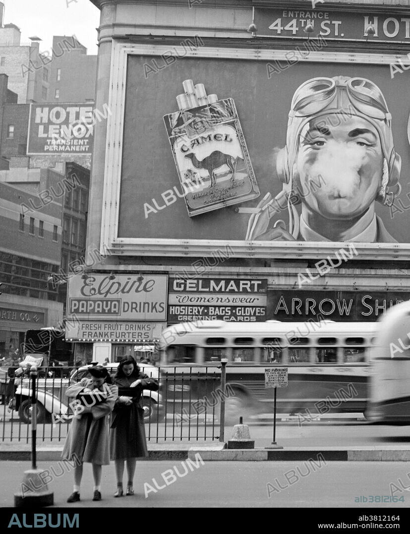 Camel cigarette advertisement at Times Square, NYC. In 1941 a billboard was installed that marked one of the most well known advertising campaigns in history; Camel cigarettes. This billboard was apart of Times Square's history for 26 long years. The billboard displayed a man blowing smoke toward his audience with "Camel" gleaming in bright lights. The billboard blew the illusion of a giant smoke ring every four seconds. Steam from a piston-driven diaphragm was forced out of a hole, and this mimicked a person smoking. Photographed by John Vachon, 1943.