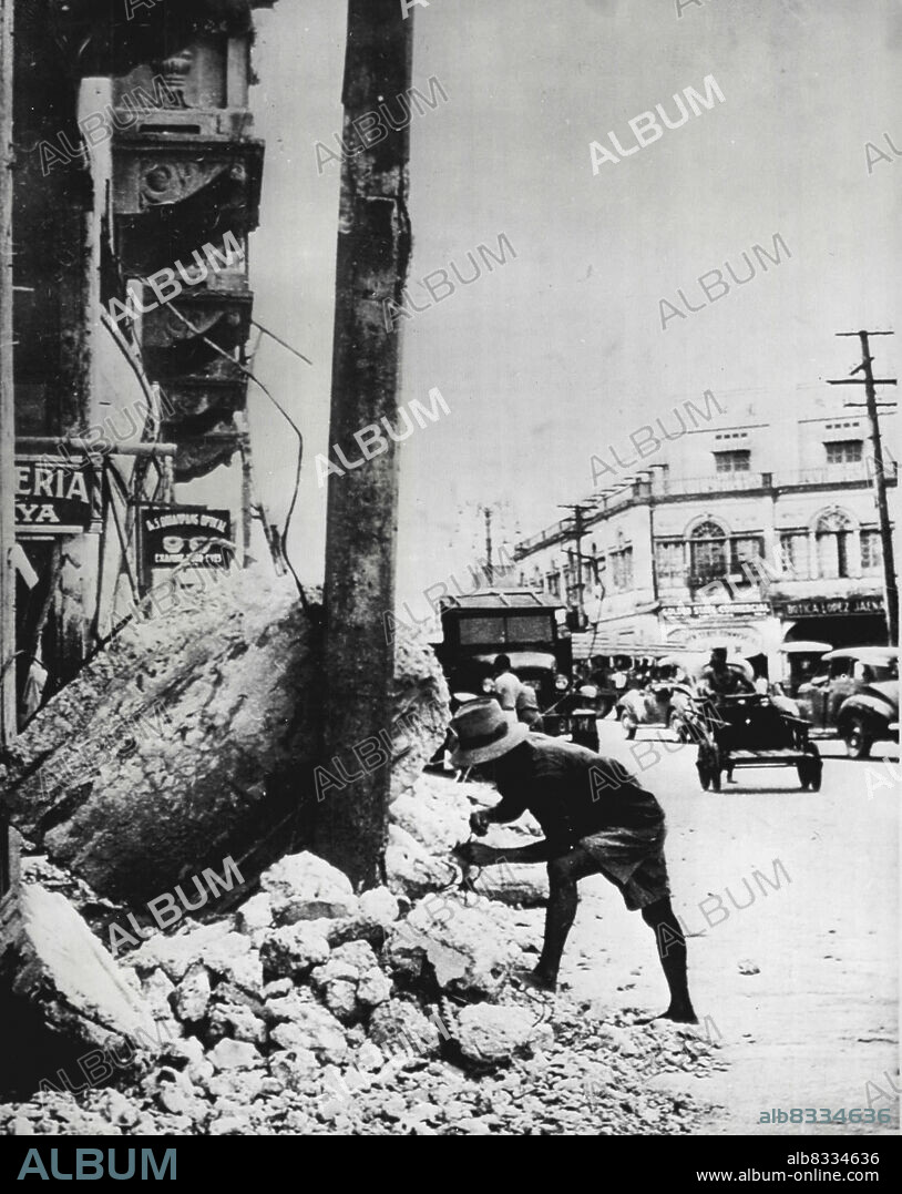 Quake Brings More Destruction - Rubble once again litters streets of Iloilo, Panay, P.I. after an earthquake Jan. 25, which took 27 lives. The city's business district was 90 percent destroyed during the war and was just reaching recovery when disaster struck again. Here a workman retrieves a broken telephone line from debris. January 29, 1948. (Photo by AP Wirephoto).