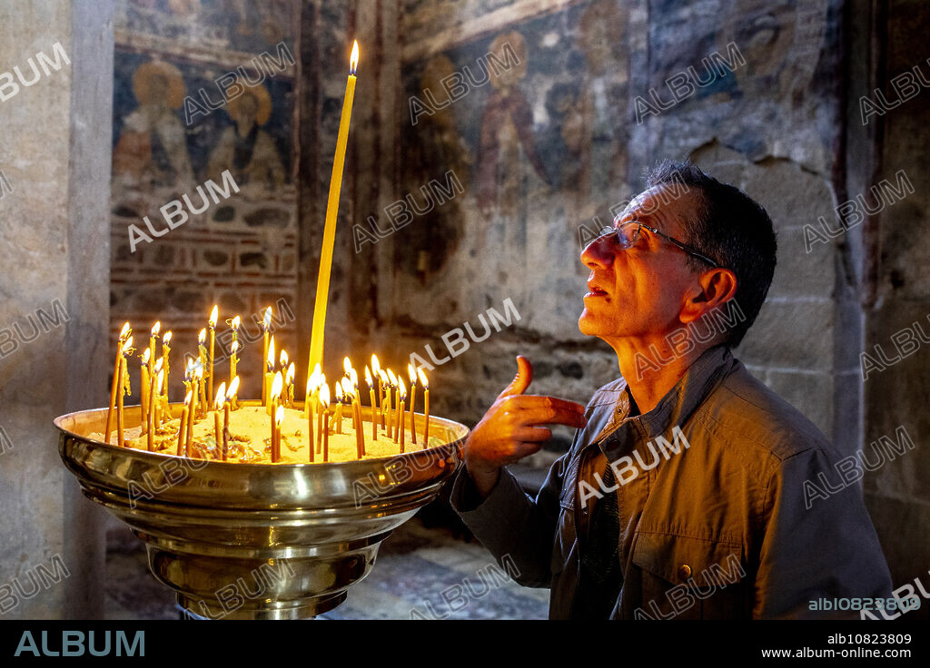 Faithful crossing himself in Visoki Decani Serbian orthodox monastery church, Kosovo.