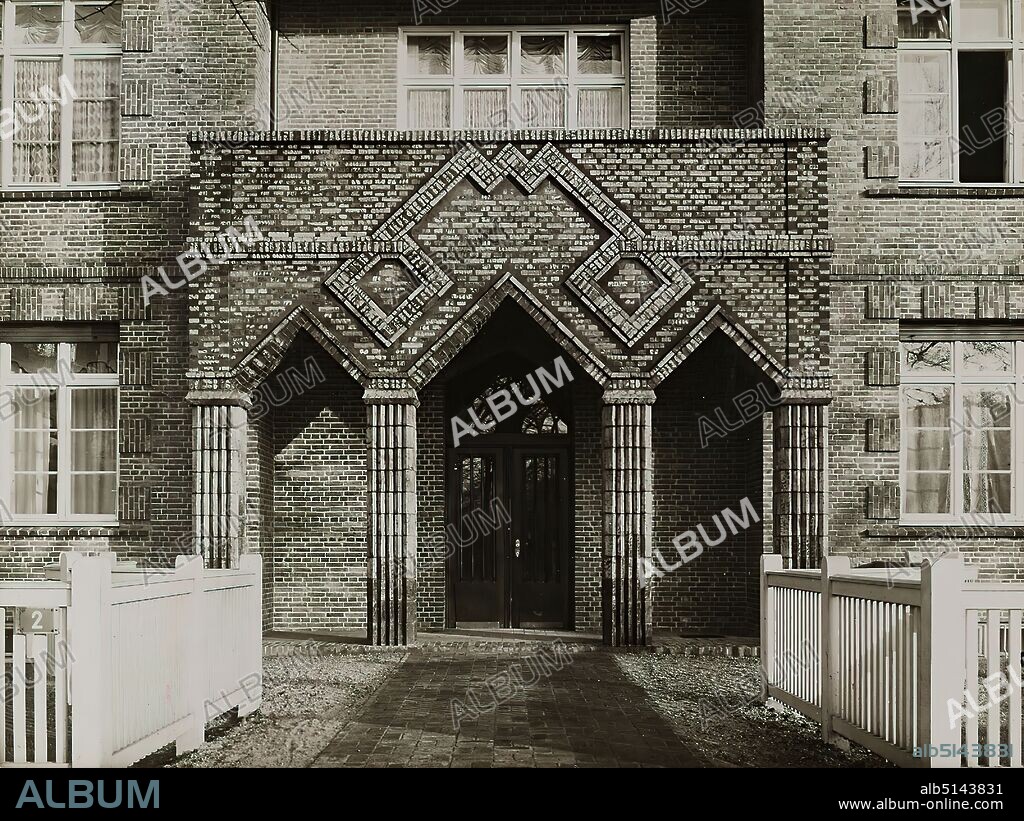 Photographenatelier Gebr. Dransfeld, Carl Dransfeld, entrance of the residential block Haynstraße 2-4, Hamburg-Eppendorf, silver gelatin paper, black and white positive process, picture size: height: 17,40 cm; width: 23,00 cm, inscribed: recto on the cardboard: in ink, o.: Photo: Dransfeld, Hamburg 39; u.: entrance of a large apartment building in Hamburg, Architekten B. D.A. Hans u. Oskar Gerson, Hamburg, architectural photography, portal/edicula, facade ,house, building, apartment building, storeyed house, architecture, The photo studio Dransfeld Bros. was founded in 1902 by the trained lithographer Carl Dransfeld and his brother, the painter Adolf Dransfeld, in Berlin and moved to Hamburg in 1904. Building director Fritz Schumacher commissioned the Dransfeld brothers to document the public buildings he had constructed since 1909. This prestigious commission established the Dransfeld brothers as leading architectural photographers in 1920s Hamburg. Among the architects for whom the studio worked were Fritz Höger, Martin Elsaesser, Distel & Grubitz or the Gerson brothers. With their photograph of the Chile House designed by Höger, Carl and Adolf Dransfeld created an icon of architectural photography. By creating a strong view from below and using a wide-angle lens, they reinforced the expressionist character of the building's top, thus contributing significantly to the popularity of modern Hamburg brick architecture. (Sven Schumacher).