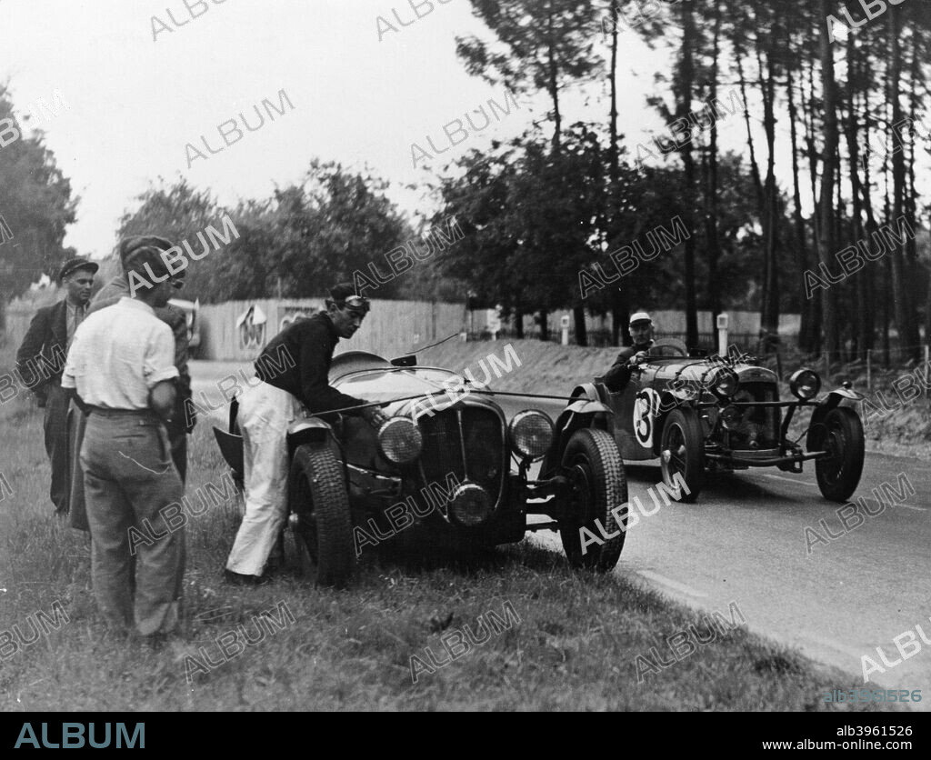 Le Mans 24 Hour Race, France, 1938. An apparently broken down Delahaye Type 135S is passed by the HRG (no 31) of Peter Clark and Marcus Chambers, who went on to claim 10th place. Delahayes finished 1st, 2nd and 4th in 1938. Clark and Chambers won the 1.5 litre class at Le Mans the following year.