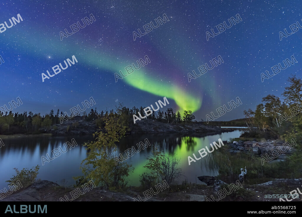 September 8, 2018 - A display of Northern Lights starting up in the twilight, over the river leading out of Tibbitt Lake, at the end of the Ingraham Trail near Yellowknife, Northwest Territories, Canada. This was the start of a fabulous display this night. Capella and Auriga are at left; the Pleiades is rising left of centre; the Andromeda Galaxy is at top.