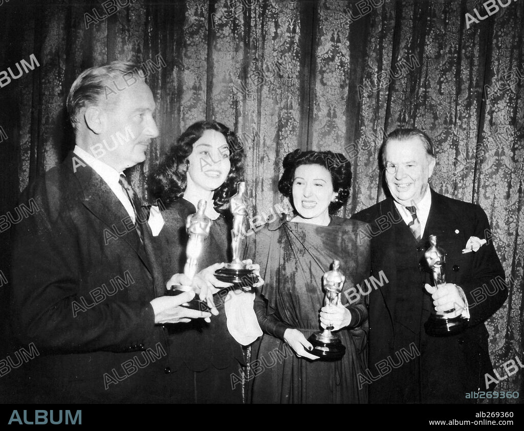 CHARLES COBURN, JENNIFER JONES, KATINA PAXINOU and PAUL LUKAS. The 16th Academy Awards / 1944. 
Paul Lukas, best actor for "Watch on the Rhine". Jennifer Jones, best actress for "The Song of Bernadette". Katina Paxinou, best actress in a supporting role for "For Whom the Bells Tolls". Charles Coburn, best actor in a supporting role for  "The More the Merrier". 1944