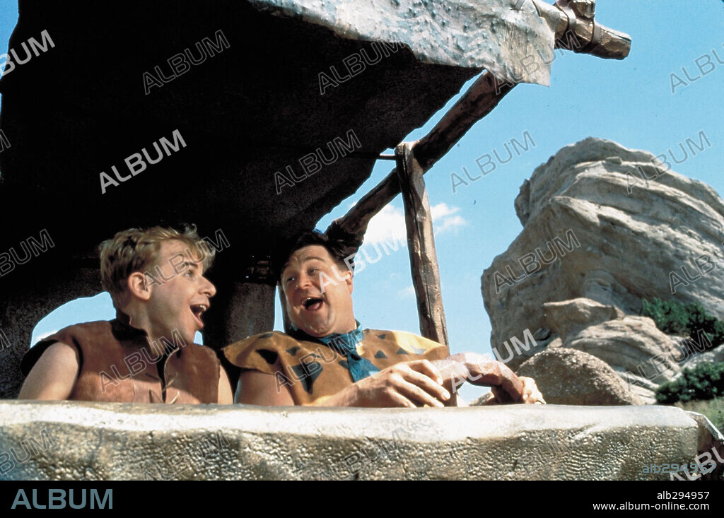 JOHN GOODMAN and RICK MORANIS in THE FLINTSTONES, 1994, directed by BRIAN LEVANT. Copyright UNIVERSAL PICTURES.