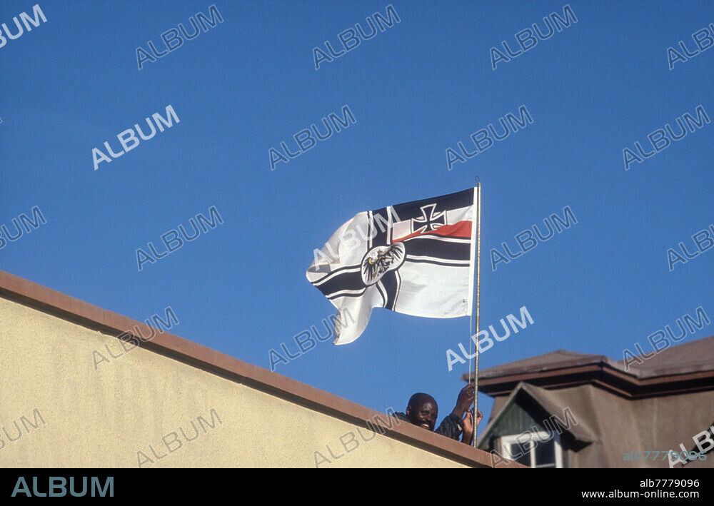 Namibia, Namibia's way to independence (1884-1920 colony German South West Africa, 1920 to 1990 as a mandate of the League of Nations part of South Africa), on the roof of an antique shop (Peter's Antiques) the German imperial war flag is raised every day. Swakopmund, 1988.