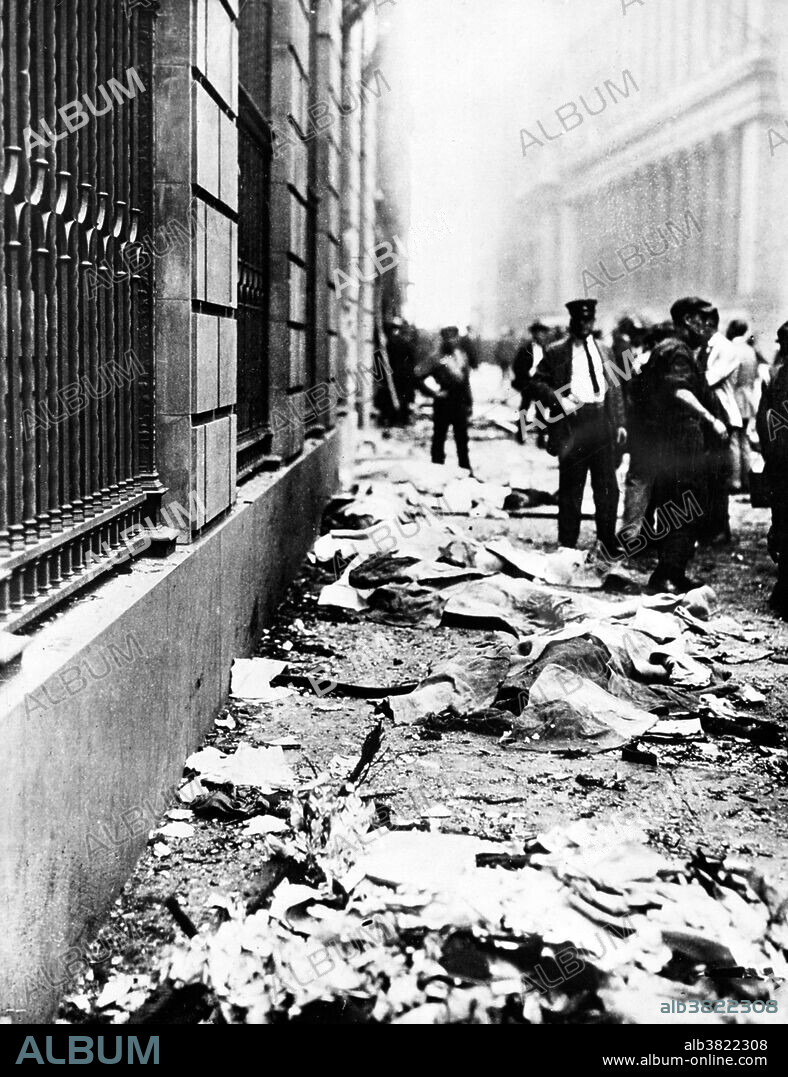 Entitled: "Bodies of dead on sidewalk following Wall St. explosion." On September 16, 1920, a horse drawn wagon stopped across the street from the headquarters of the J.P. Morgan bank at 23 Wall Street. Inside the wagon, 100 lbs of dynamite with 500 lbs of cast-iron sash weights exploded in a timer-set detonation. The horse and wagon were blasted into small fragments, but the driver was believed to have left the vehicle and escaped. The 38 victims, most of whom died within moments of the blast, were mostly young people who worked as messengers, stenographers, clerks, and brokers. The bomb caused more than $2 million in property damage ($23,500,000 with inflation) and destroyed most of the interior spaces of the Morgan building. There were 143 seriously injured, and the total number of injured was in the hundreds. The bombing was never solved, although investigators and historians believe the Wall Street bombing was carried out by Italian anarchists, a group responsible for a series of bombings the previous year. Photographed by the New York World-Telegram and the Sun Newspaper, 1920.