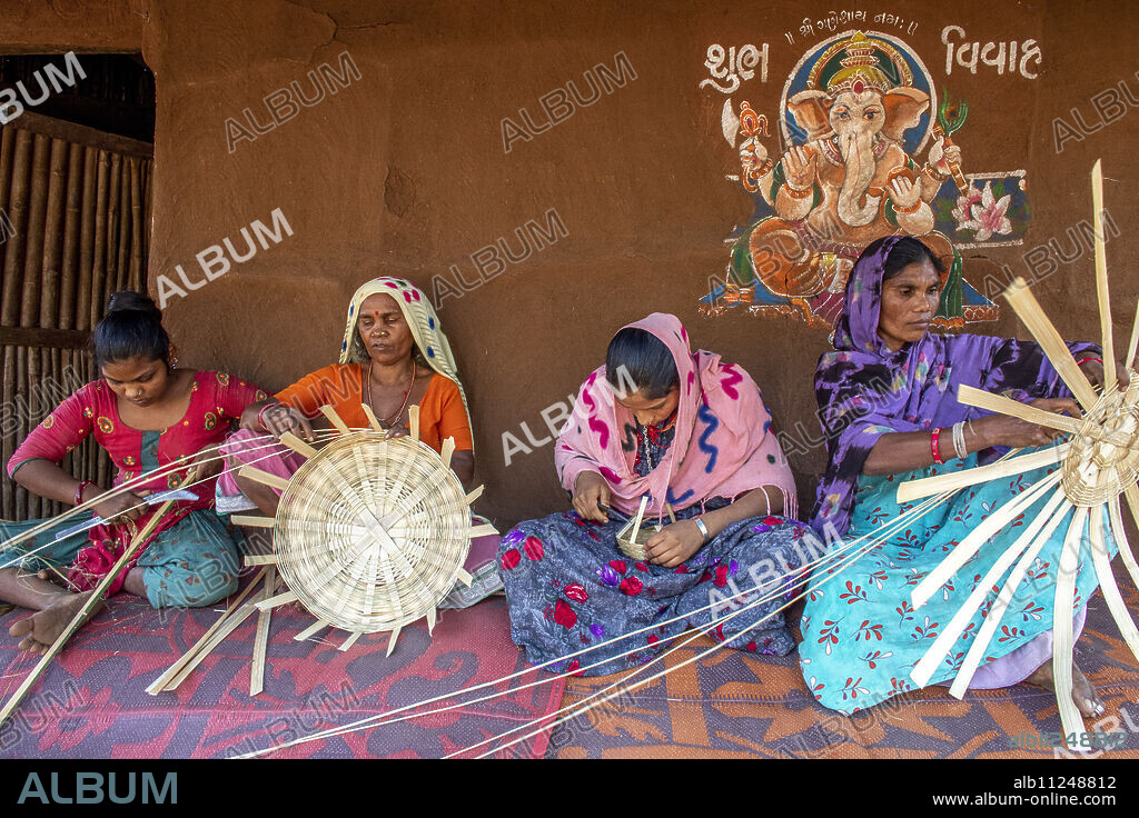 Adivasi women making baskets in a village in Narmada district, Gujarat, India.