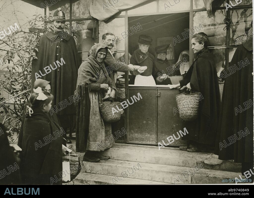 Madrid, 16/12/1918. En el asilo de Lavanderas, en Madrid, S.M. la Reina María Cristina de Habsburgo, repartiendo a los pobres raciones que costea durante el invierno.