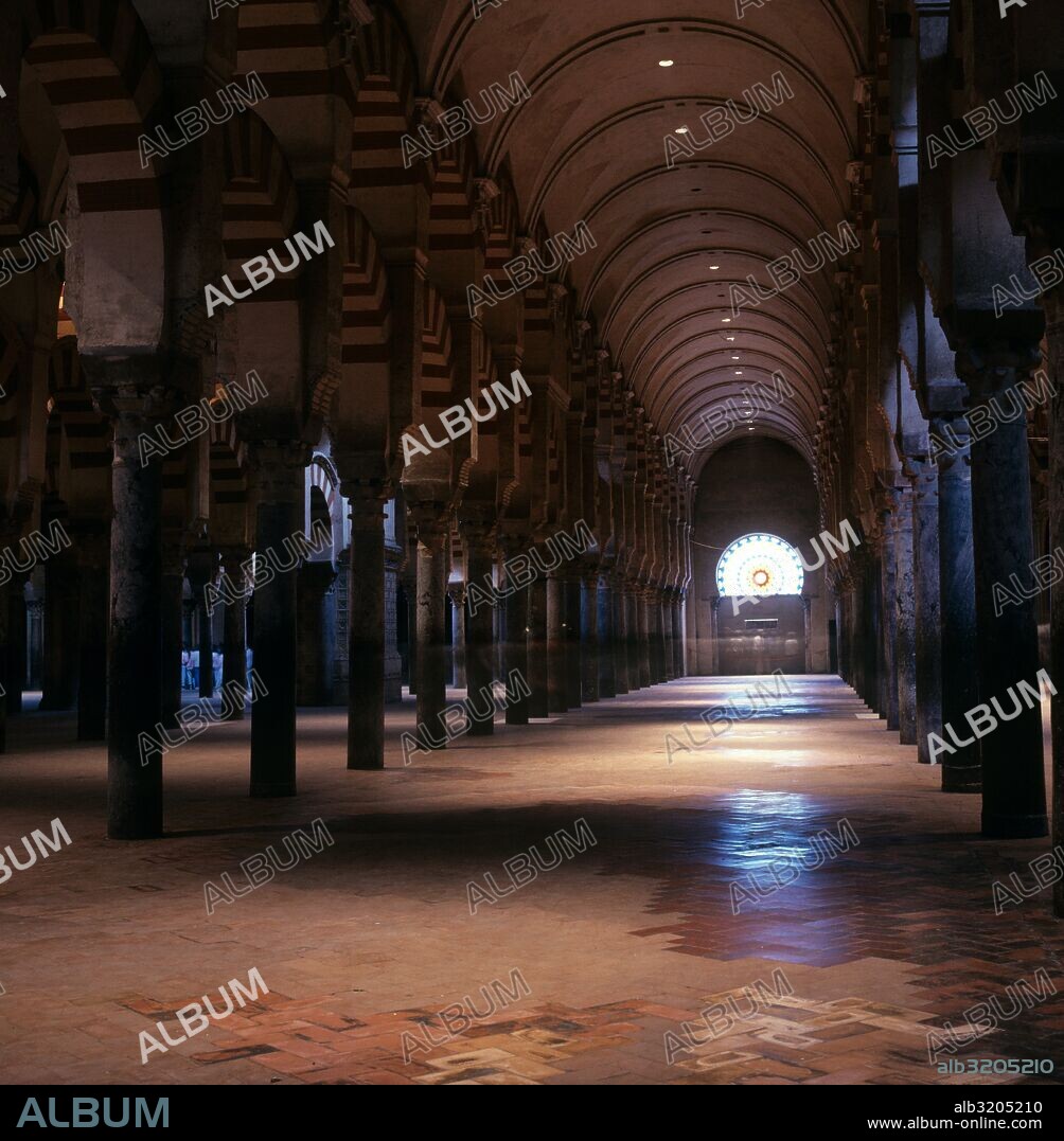 MEZQUITA DE CORDOBA. VISTA DEL ESPACIO DE COLUMNAS. AL FONDO VIDRIERA EN FORMA DE ROSETONARCOS CON DOVELAS EN ROJO Y BLANCO.  CORDOBA, ESPAÑA.