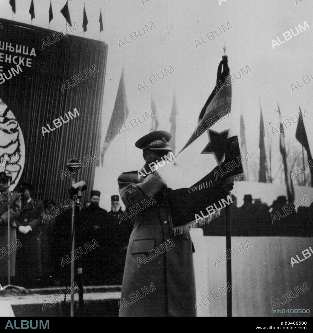 Tito Kisses The Flag -- At a ceremony to mark the tenth anniversary of the Yugoslav People's Army. Marshal Tito Kisses the new army flag before presenting it to one of the Proletarian brigades. December 28, 1951.