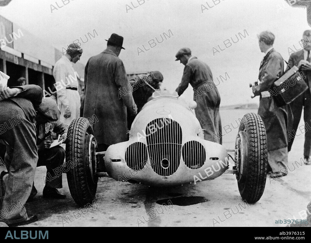 Mercedes-Benz W125 Grand Prix car at the Nurburgring, Germany, 1937. The Mercedes-Benz W125 was the ultimate pre war Grand Prix car with the most powerful engine seen in Grand Prix racing until the turbo era in the 1980s. Mercedes drivers won six races in the car in 1937, Rudolf Caracciola, with four of them, becoming European Champion in the process. This is the car of Manfred von Brauchitsch. The unmistakable figure of Alfred Neubauer, Mercedes team manager, stands next to the car with his back to the camera.
