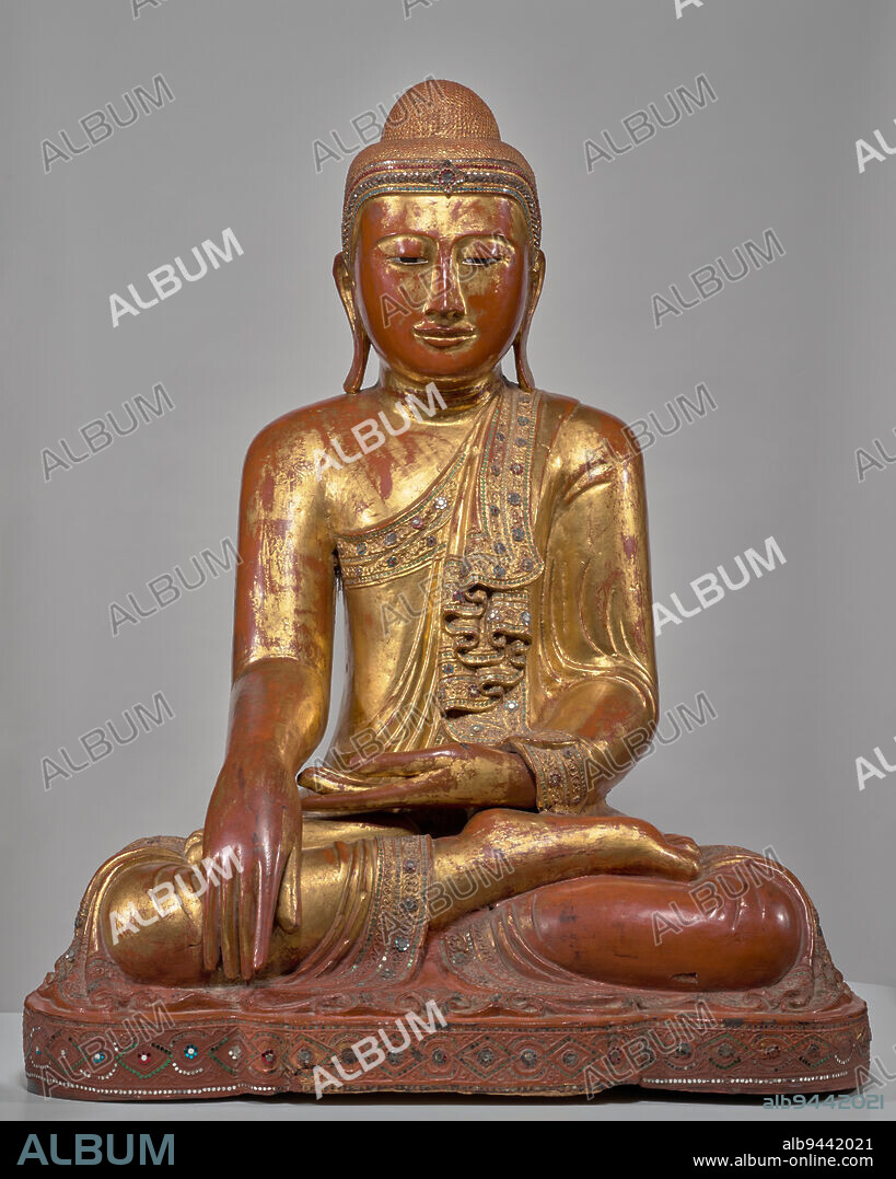 Enshrined Buddha, c. 1850, 41 1/2 x 32 x 23 in. (105.41 x 81.28 x 58.42 cm), Wood, lacquer, gold leaf, mirrors and colored glass inlay, Myanmar (Burma), Mandalay Style, Seated in the bhumisparamudra, or earth-touching gesture, this statue depicts the Buddha just before his enlightenment under the bodhi tree. The events leading up to this moment are often described as a powerful battle between good and evil, delusion and insight. Mara, the god of illusion, attacked the Buddha, challenging the young princes right to destroy him. In response, the Buddha reached his right hand down, calling the earth as witness to his good deeds over many lifetimes. In accounts from Southeast Asia, the goddess of the earth emerged and flooded the earth, destroying Mara and his armies.