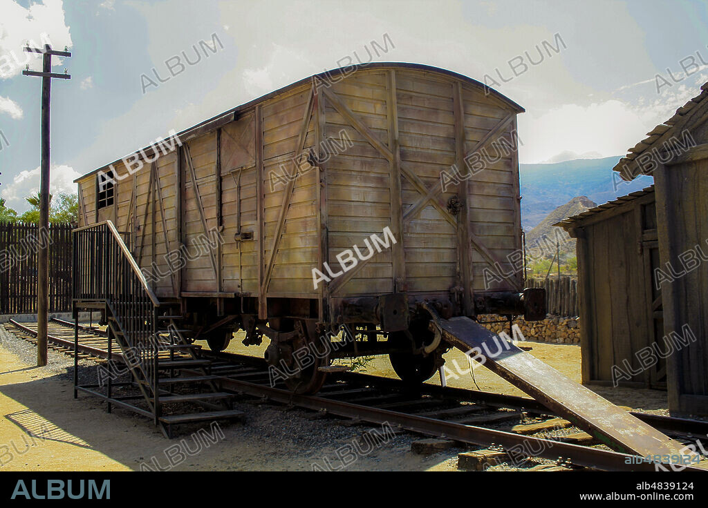 Province of Almería, Andalusia, Spain, Europe. Tabernas Desert (Desierto de Tabernas). Mini Hollywood film set, western theme park. A carriage of a freight train on a dead track at the railway station.