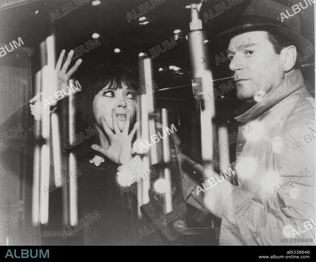 ANNA KARINA and EDDIE CONSTANTINE in ALPHAVILLE, A STRANGE CASE OF LEMMY CAUTION, 1965 (ALPHAVILLE, UNE ETRANGE AVENTURE DE LEMMY CAUTION), directed by JEAN-LUC GODARD. Copyright CHAUMIANE/FILM STUDIO.