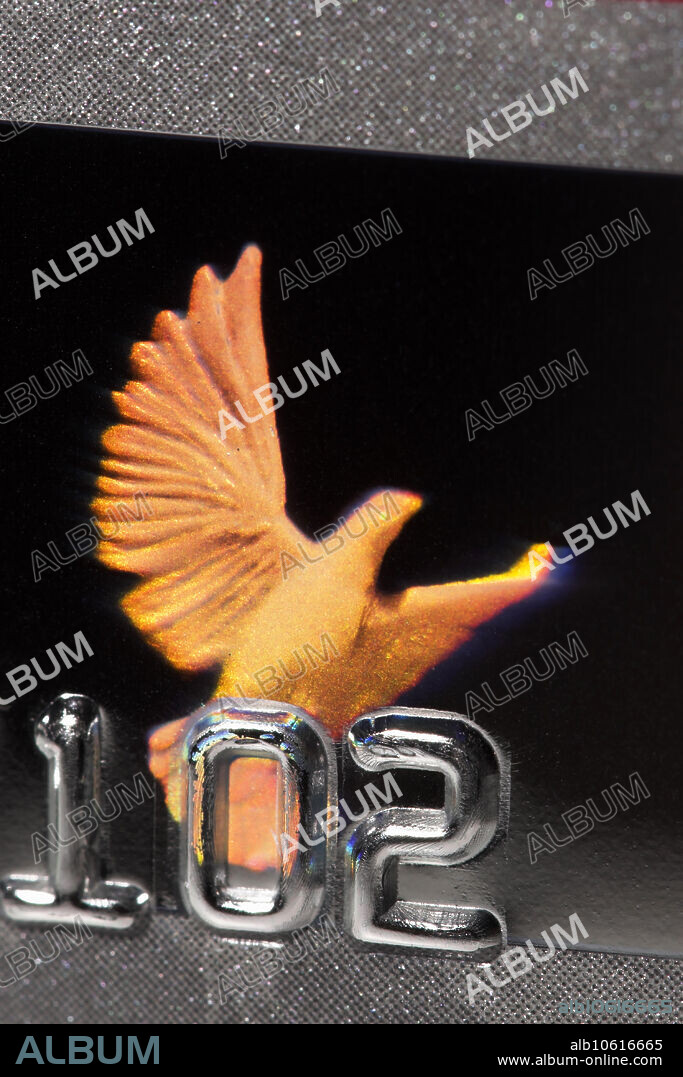 VISA dove hologram reflects different colors. The VISA dove shown here is an embossed hologram that is mass produced at low cost. An embossed hologram is a microscopic surface relief pattern. Optically, it is essentially a reflective diffraction grating. Since the diffraction angle is wavelength-dependent, the hologram seems to shift its colors when illuminated by white light and observed from different angles.