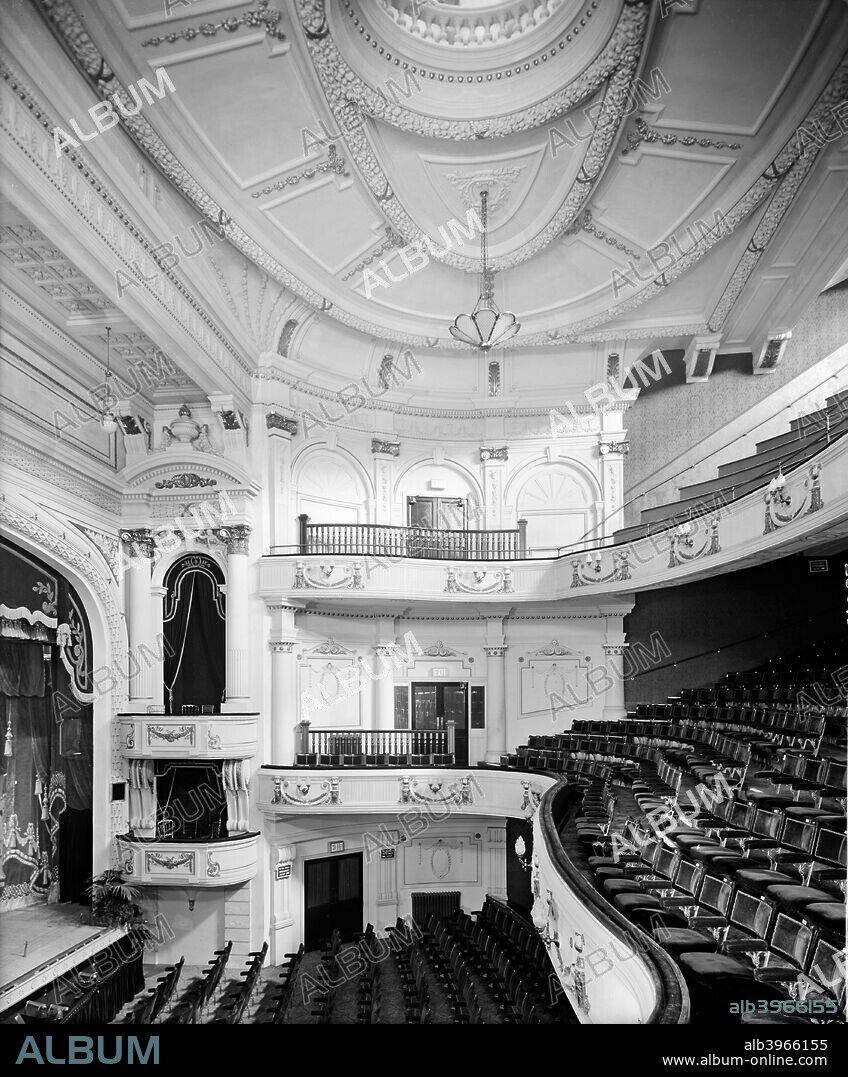 Interior of the Empire Theatre, Penge, Bromley, London, (c1920-c1940?). Showing boxes with pediment above, stalls circle and upper circle. All are richly ornamented, as is the ceiling plasterwork.
