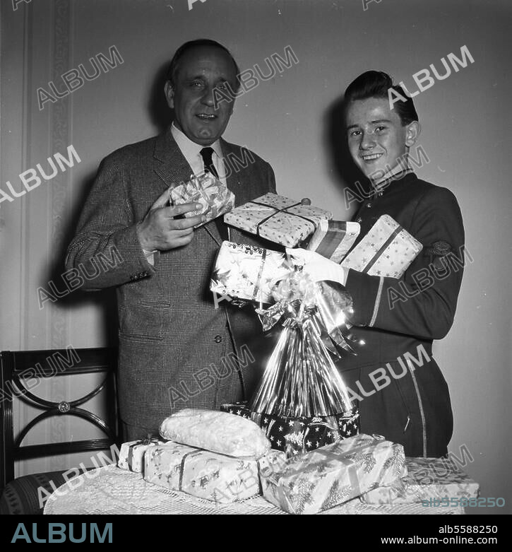 Hasse, O.E. (Otto Eduard); Schauspieler; Obersitzko (Posen) 11.7.1903 - Berlin 12.9.1978. O.E. Hasse übergibt Weihnachtspäckchen an einen Pagen des Hamburger Hotels Atlantic. Foto, 9.12.1955.