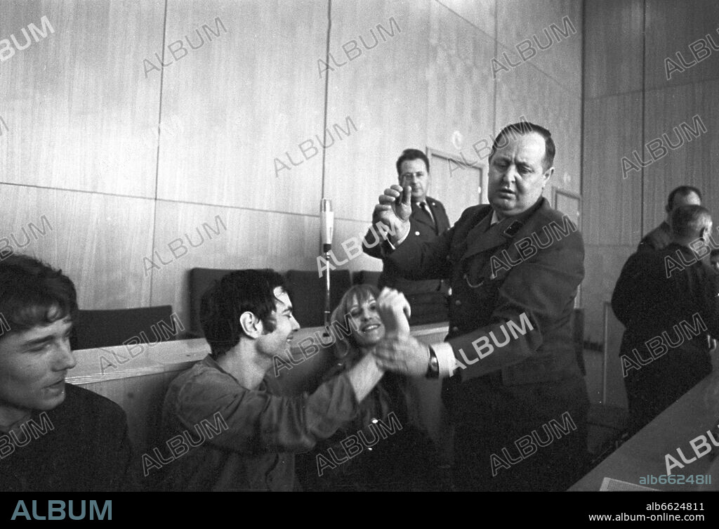 The defendents (l-r) Horst Söhnlein, Andreas Baader snd Gudrun Ensslin (Thorwald Proll not to be seen) shortly before the conviction in the shopping mall arsonist legal proceedings on the 31st of October in 1968 in Frankfurt am Main.
A judicial officer takes away a cigarre from Andreas Baader.  Affrays started, the court room was cleared. The defendants received a sentence of three years for arson with possible danger for people.
 
Photo: Manfred Rehm +++(c) dpa - Report+++. 31/10/1968