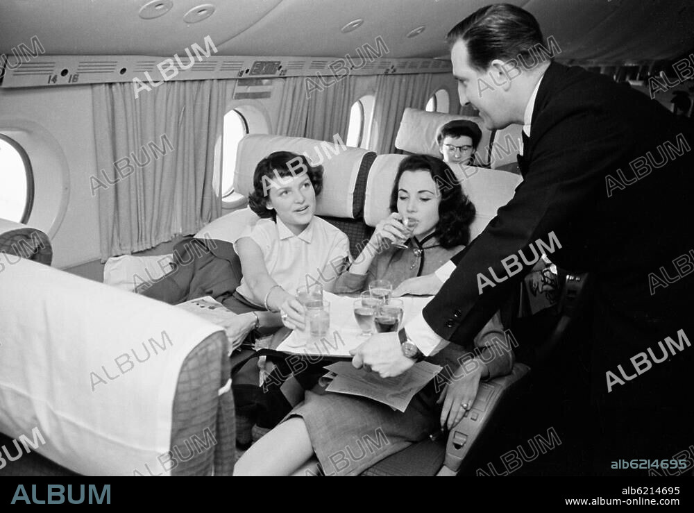 Luftfahrt: Flugzeuge.-Flugzeug der "Pan American World Airways" auf dem Flug von Orly (Frankreich) nach Rom (Italien): Ober bietet zwei jungen Frauen ein Erfrischungsgetränk an.-Foto, 1950er Jahre. Aus einer Serie "Week end à Rome".