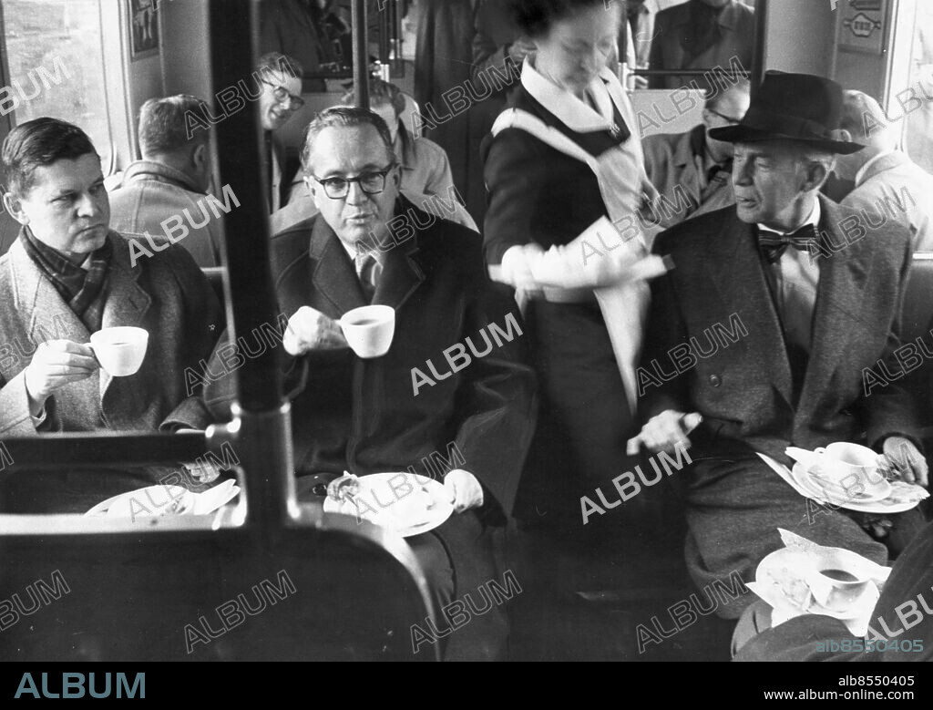 Stockholm 1958-11-18. Tunnelbanan, södra invigningen. Borgarråden Erik Huss och Helge Berglund samt överståthållare Johan Hagander tillhörde gästerna vid den unika kaffeserveringen pa T-banetåget på sträckan BagarmossenFarstaHässelby Strand.. Med flaggor både bak och fram, kaffe med dopp åt alla 350 passagerarna, rökförbudet upphävt och askkoppar istället framsatta åt dem som blossade på spårvagens invigningscigarrer rullade på tisdagsmiddagen första tunnelbanetåget fram till Bagarmossen, Farsta och Hässelby strand. Det var fem kilometer nya tunnelbanor som invigdes denna dag, nästan exakt ett år efter premiären (den 24 november) på felande länken" mellan Hötorget och Slussen.. Foto: Olle Seijbold / DN / TT / Kod: 51. ** SvD OUT **.
