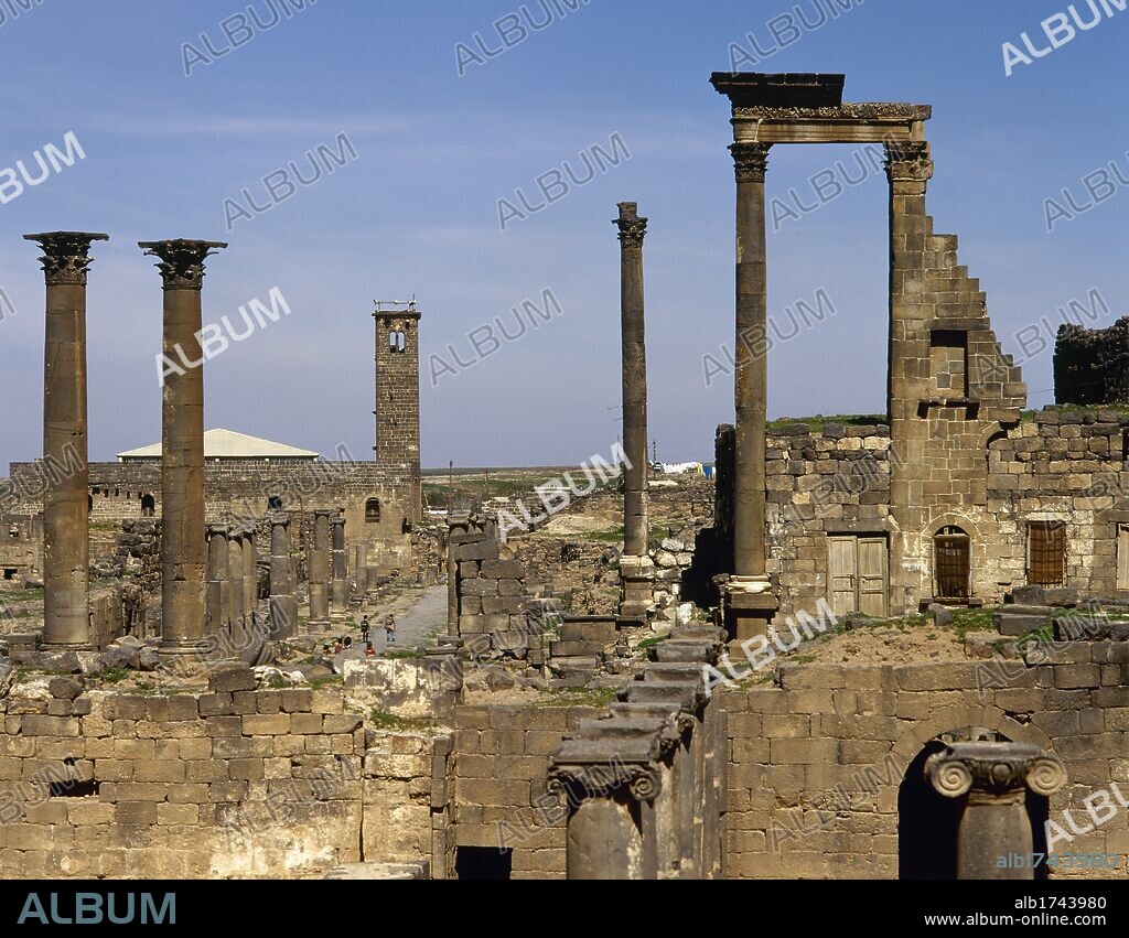 Syria, Bosra. Ancient Roman city. Ninfeo. Remains of the Corinthian capitals, 2nd century AD. In the background the mosque of Al-Omari. Photo taken before the Syrian civil war.