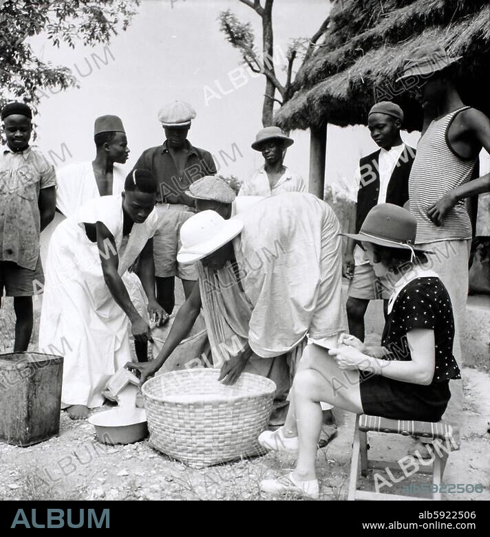 Afrika / Kolonialgeschichte / Französisch-Guinea (1895-1958 franz. Kolonie). Auf der Bananenplantage des französischen Kolonisten Eric Allégret: Madame Allégret kontrolliert die Lebensmittelverteilung an afrikanische Arbeiter. Foto, Dezember 1939, von Denise Bellon (1902-1999).
