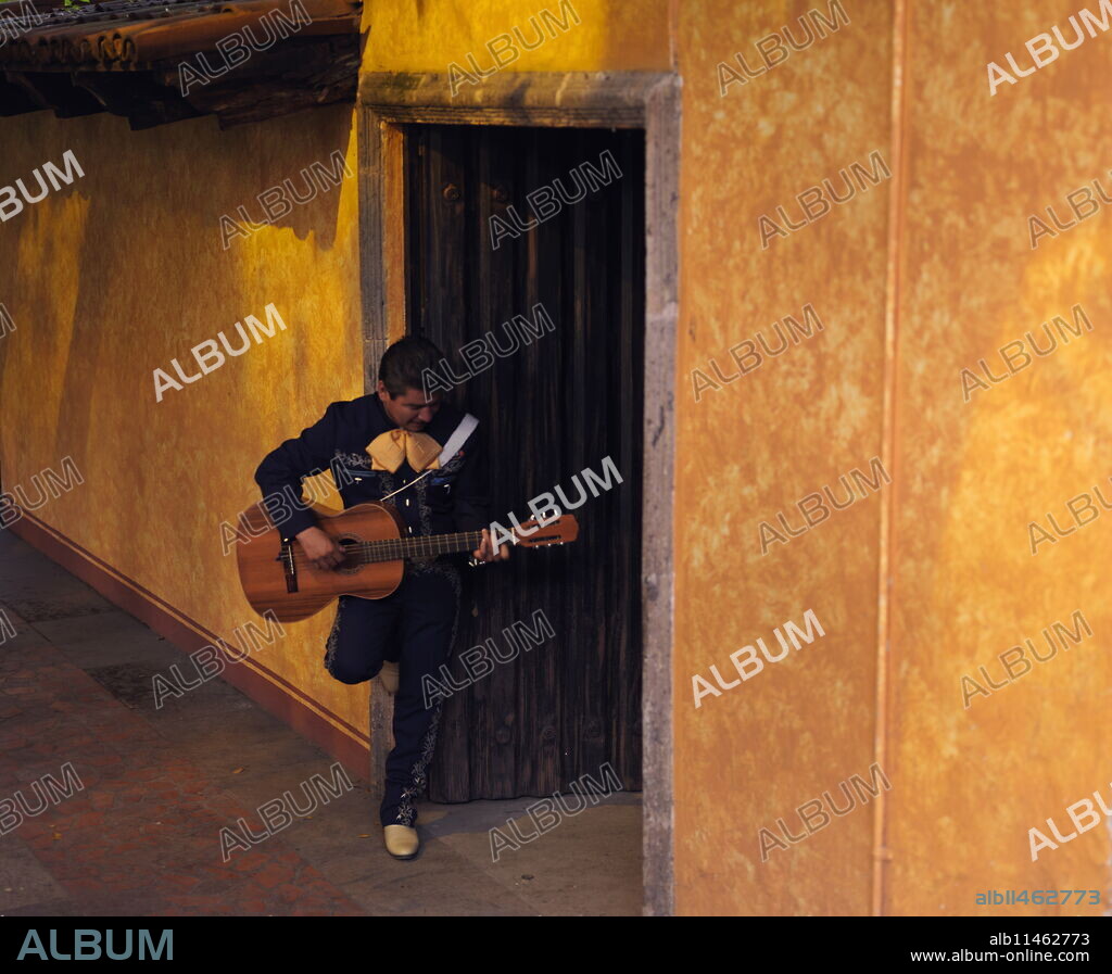 Musician playing guitar in an open doorway, Tequila, Jalisco, Mexico, North America.