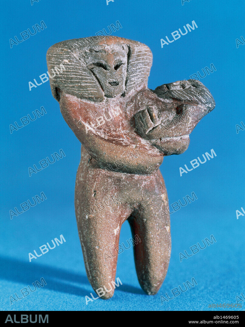 ARTE PRECOLOMBINO. Fase CULTURA VALDIVIA (3500 a. C. -1900 a. C.). Figura de cerámica probablemente moldeada a mano. Representa una mujer desnuda con un niño en brazos. Procede de las costas de la Provincia de Guayas. Ecuador.