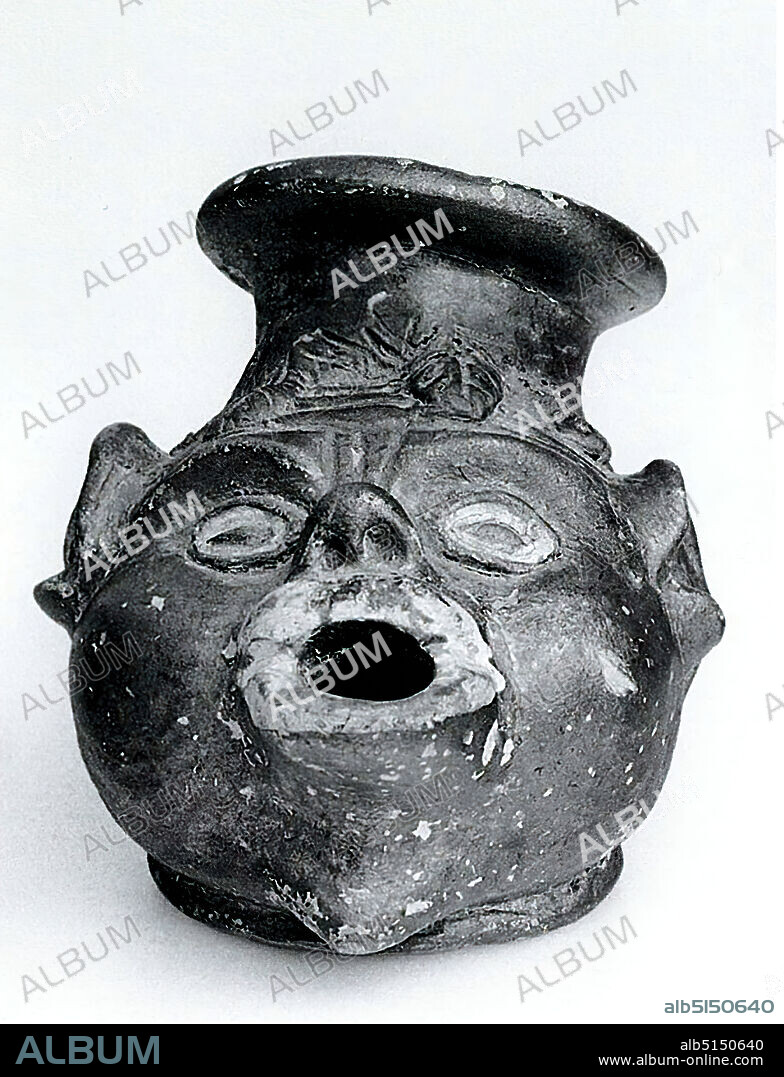 Oil lamp in the shape of an African head, clay, pressed into the mold, hand modeled, clay, pressed into the mold and hand modeled, Total: Height: 7.9 cm; Width: 12.7 cm; Depth: 7.8 cm, ceramic, actor, actress, African, mask, Late Classicism (Greek Antiquity), Early Hellenistic, Greek Antiquity, The black varnished oil lamp is designed in the shape of a head. The head, leaning backwards, has a short, round vessel neck with a rim on the skull, to which the handle pierced on its upper side is attached at the back. The bent up nose and the protruding eyes, which are white-margined inside, are striking. The cheeks are inflated, the ears are protruding. The strongly protruding mouth is round open and served to receive the wick. The plastically indicated hair falls in thick strands across the forehead. Because of the distorted facial features, the head is called grotesque. It is probably a theater mask or a genre representation popular since early Hellenistic times. Michel Sguaitamatti assigns the head to an African.
