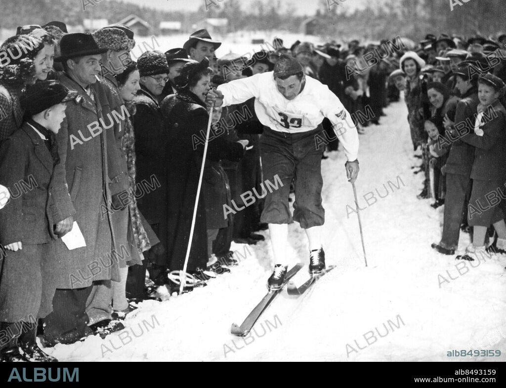 ESKILSTUNA 1950-01-08.. Nils "Mora-Nisse" Karlsson, skidåkare, vinner uttagningen i Eskilstuna för skid-VM i Lake Placid, påhejdad av supporters.. Foto: Bo Dahlin / AB Text & Bilder / SVT / Kod: 5600. Mapp: Karlsson, Mora-Nisse i aktion -B. Skidåkning Längdskidåkning Vinnare Segrare Vintersport Åskådare.