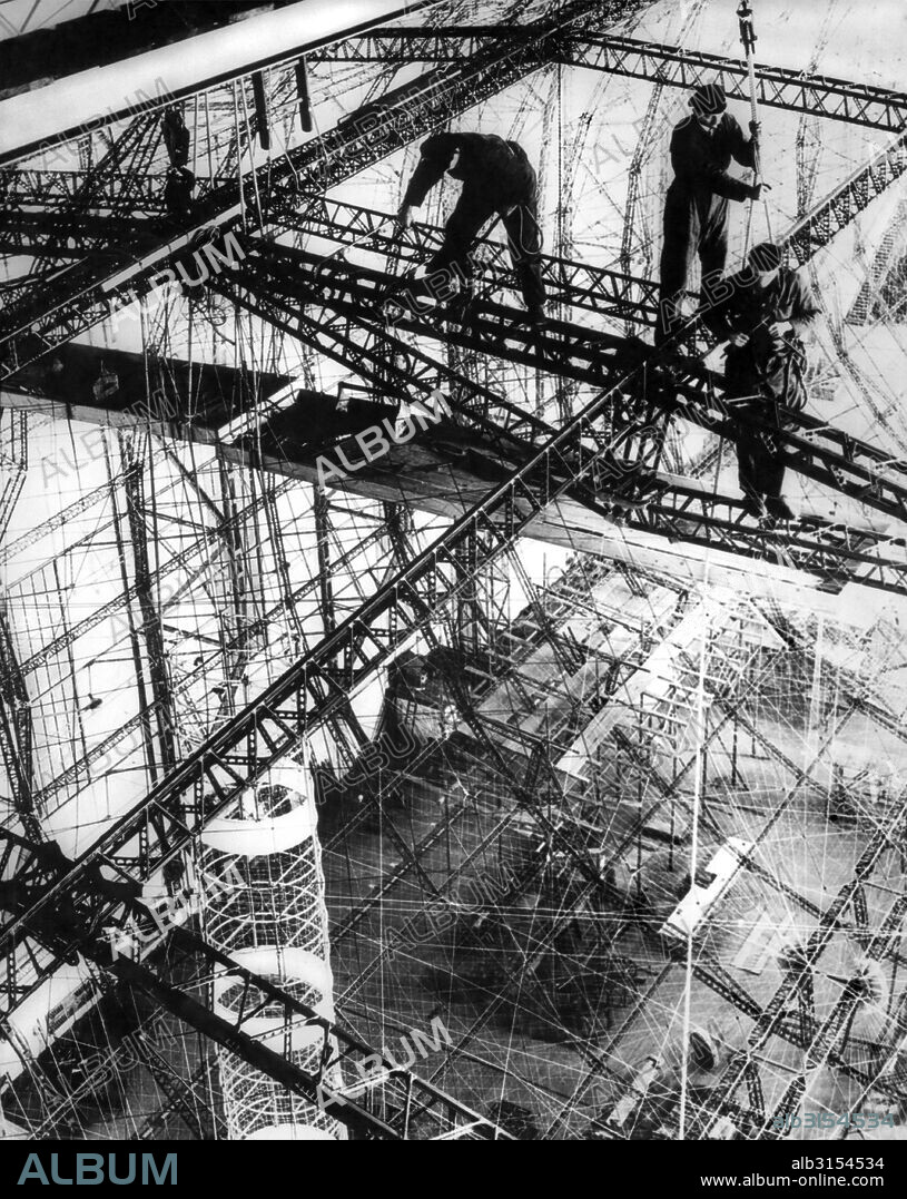 Friedrichshafen, Germany:  c. 1933. The frame of the LZ 129 is taking shape at the Zeppelin Works in Friedrichshafen. It was soon to be named after the late Paul von HIndenburg, the President of Germany, who died in 1934. The frame was made of Duralumin, one of the earliest aluminum alloys, and  the skin was of to be of cotton that was doped with a mixture of aluminum and iron oxide to protect it against ultraviolet and infrared light. Unfortunately, this mixture reacted violently when it was heated, resulting in extremely high temperatures.