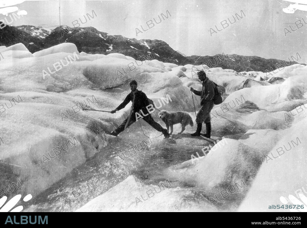 British Arctic Air Route Expedition - Scott and Lindsay crossing a thaw stream in the middle of the glacier. September 15, 1931. (Photo by British Arctic Air Route Expedition Photograph).