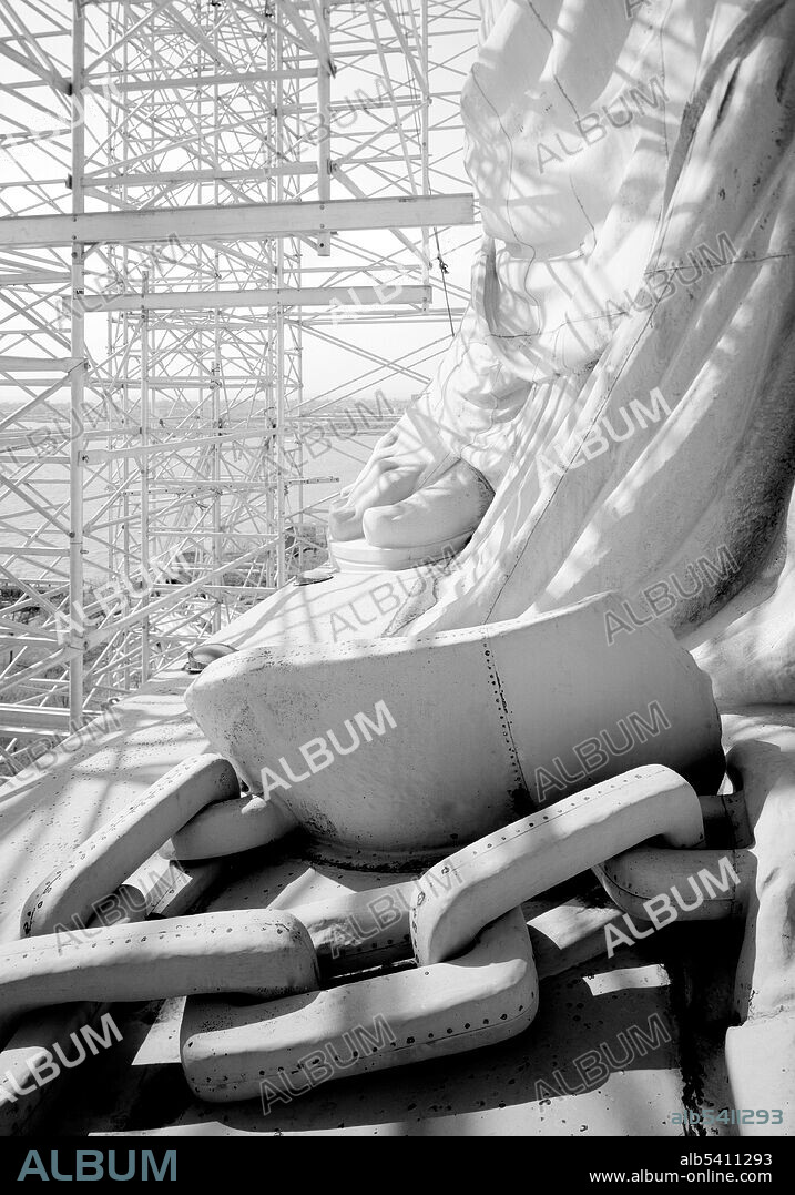 Broken shackles, axe head and right foot at base. A centennial conservation-restoration of the Statue of Liberty occurred between 1984-86. The Statue of Liberty, by French sculptor Frédéric Auguste Bartholdi, is a colossal artwork on Liberty Island in New York Harbor, and is a part of the Statue of Liberty National Monument. Much of the restoration effort was based on unprecedented restorative methods, as metallurgical repair work on such a large scale had never been attempted. Many scientists, engineers, government organizations, and professional consultants evaluated and dealt with the various problems and tasks facing the restoration effort. Historic American Engineering Record, Jet Lowe, 1984 (cropped and cleaned).