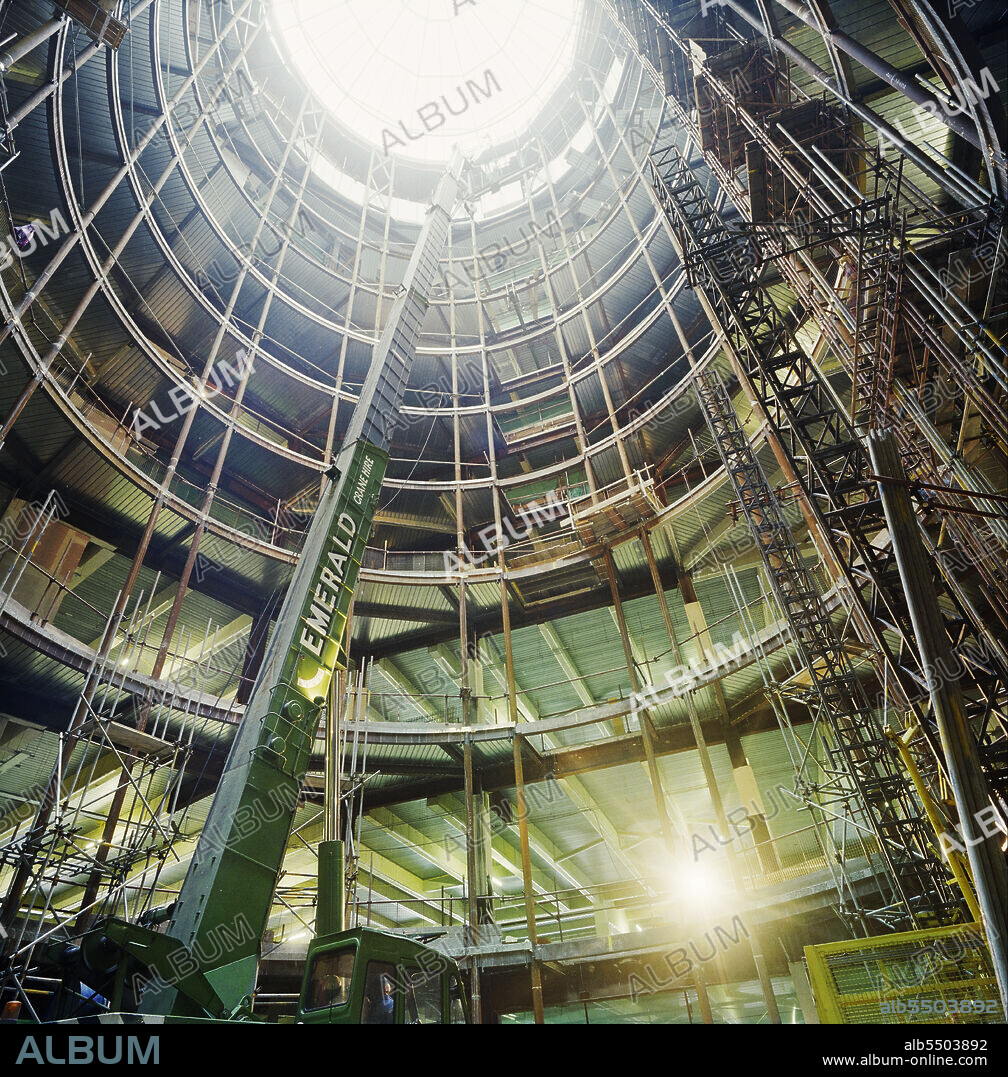 JOHN LAING PLC. 3 Minster Court, Mincing Lane, City of London, 04/04/1991. Looking up through the central atrium of 3 Minster Court during fitting-out work. In October 1990, Laing’s London division were awarded the contract for the fitting out of the new London Underwriting Centre at No.3 Minster Court. Key parts of the contract included altering steelwork to enable 16 escalators to be suspended in the atrium, creating dining and kitchen areas on the mezzanine level and the installation of raised floors and suspended ceilings. In August 1991, the team faced a huge setback as the site was severely damaged by fire. The flames swept through the central atrium and burst through the roof. A new Laing team was formed to restore the building after the disaster, and work was finally completed in late 1993.