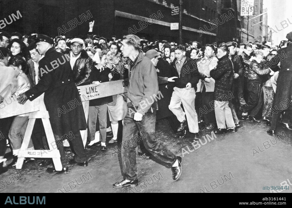 New York, New York: February 23, 1957 Teenage Rock 'N' Roll fans on 44th Street are restrained by police as they line up to see disc jockey Alan Freed and the movie, 'Don't Knock The Rock'.