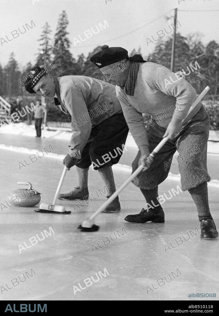 STOCKHOLM 1947-02-25.. En svensk-skotsk curlingtävling går av stapeln på Tennisstadion. Här ses George Reid (tv) och Hugh K. Miller sopa frenetiskt framför den framglidande curlingstenen.. Foto: AB Text & Bilder / SVT / Kod: 5600. Mapp: Svensk curling I:34 1/2A. Kvastar.