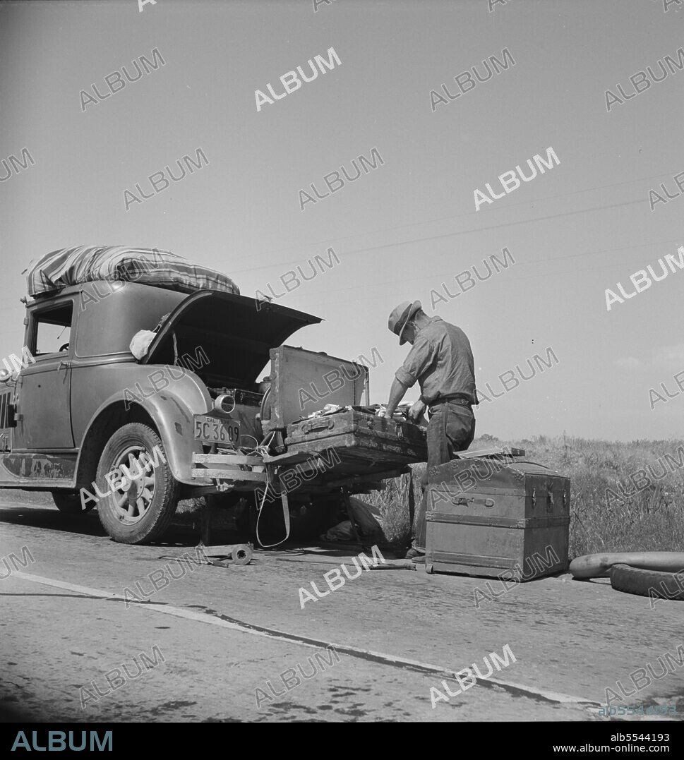 DOROTHEA LANGE. Car trouble on west side, Highway no. 33. In San Joaquin Valley. Formerly a California cowhand and roving laborer, now with wife, he follows the fruit. "My uncle homesteaded here sixty years ago. I'm lower on money than at any time".