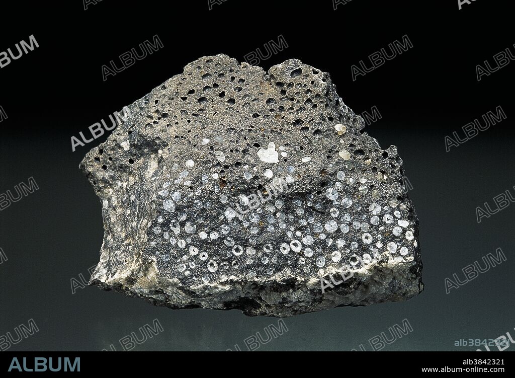 Vesicular basalt (igneous rock) from Colorado, USA, with calcite filled vesicles. Basalt is a hard and dense volcanic rock. Dimensions: 8 x 6 x 3.5 cm.
