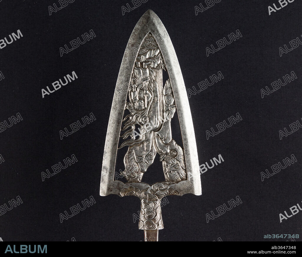 Ceremonial Arrowhead (Yanone). Culture: Japanese. Dimensions: L. 12 3/4 in. (32.4 cm); L. of head 6 in. (15.7 cm); W. 2 3/4 in. (7 cm); Wt. 7.1 oz. (201.3 g). Steel-chiseler: Umetada Motoshige (Japanese, Edo period, died 1675). Date: dated August 1645.
Large arrowheads, pierced and elaborately chiseled with landscapes, birds, flowers, dragons, and Buddhist divinities, were created to be admired for the beauty of their metalwork and design rather than for use in archery. This arrowhead is dated 1645 and signed by Umetada Motoshige (died 1675), a member of the Umetada school of swordsmiths, <i>tsuba</i> makers, and iron chiselers. It belongs to a group of more than thirty similarly signed and dated pieces in the Metropolitan Museum's collection (including acc. nos. 32.75.318, .321, .327, .330, .334, .337, .339-.340, .399, .403, .406, .409) that may have been made for presentation or as a votive offering to a shrine. The decoration depicts a landscape witht he Buddhist divinity Fudo Myo-o and a waterfall.